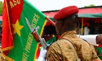 Militærmand, der holder Burkina Fasos flag