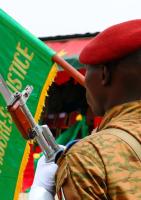 Militærmand, der holder Burkina Fasos flag