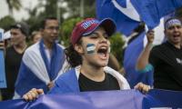 Woman demonstrating with Nicaraguan flag on her cheeks